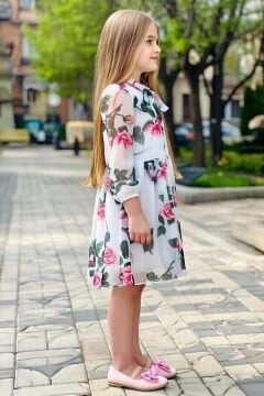 Kız Çocuk Üzeri Çiçek Baskılı ve Yakadan Bağlamalı Eteği Pliseli Beyaz Elbise