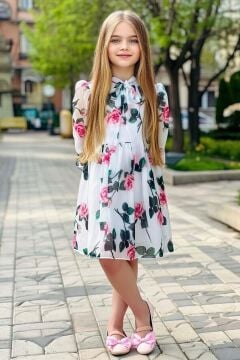 Kız Çocuk Üzeri Çiçek Baskılı ve Yakadan Bağlamalı Eteği Pliseli Beyaz Elbise