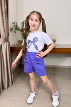 Kız Çocuk Üzerinde Digital Kurdela Basklı T-Shirt ve Fiyonk Cep Detaylı Lila Şortlu Takım