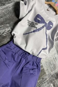 Kız Çocuk Üzerinde Digital Kurdela Basklı T-Shirt ve Fiyonk Cep Detaylı Lila Şortlu Takım